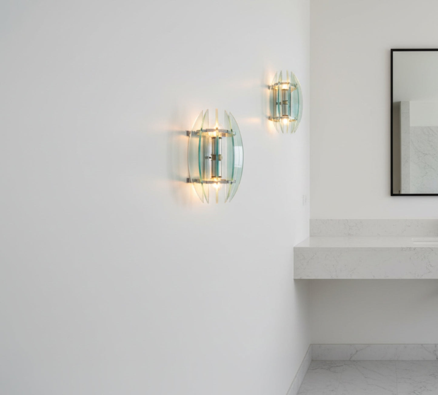 Glass wall sconce with multiple layers of green glass on a white background