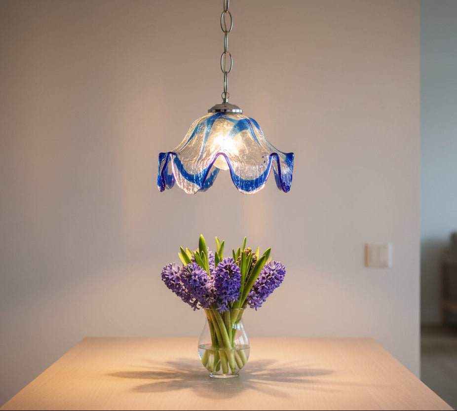 Pendant light with blue glass shade on a white background